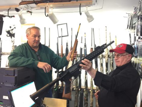 A & J owner Joe Aberdare explains the features of a Browning rifle. Firearms instructor and employee Richard Bailly holds up a Ruger semi automatic rifle. Photo: Heather Bellow