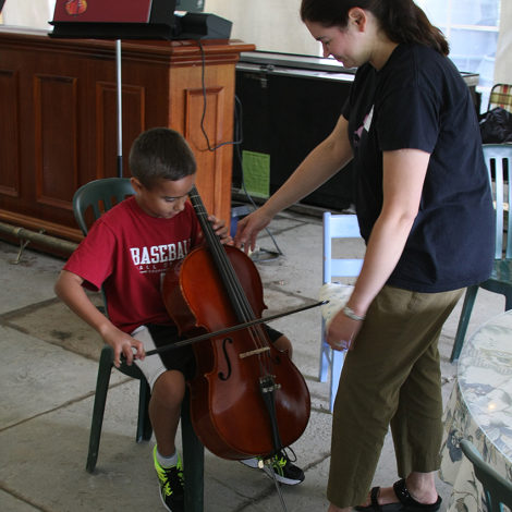 Anna Anderson demonstrates the cello for Danny Mankes at the Instrument Playground on August 2