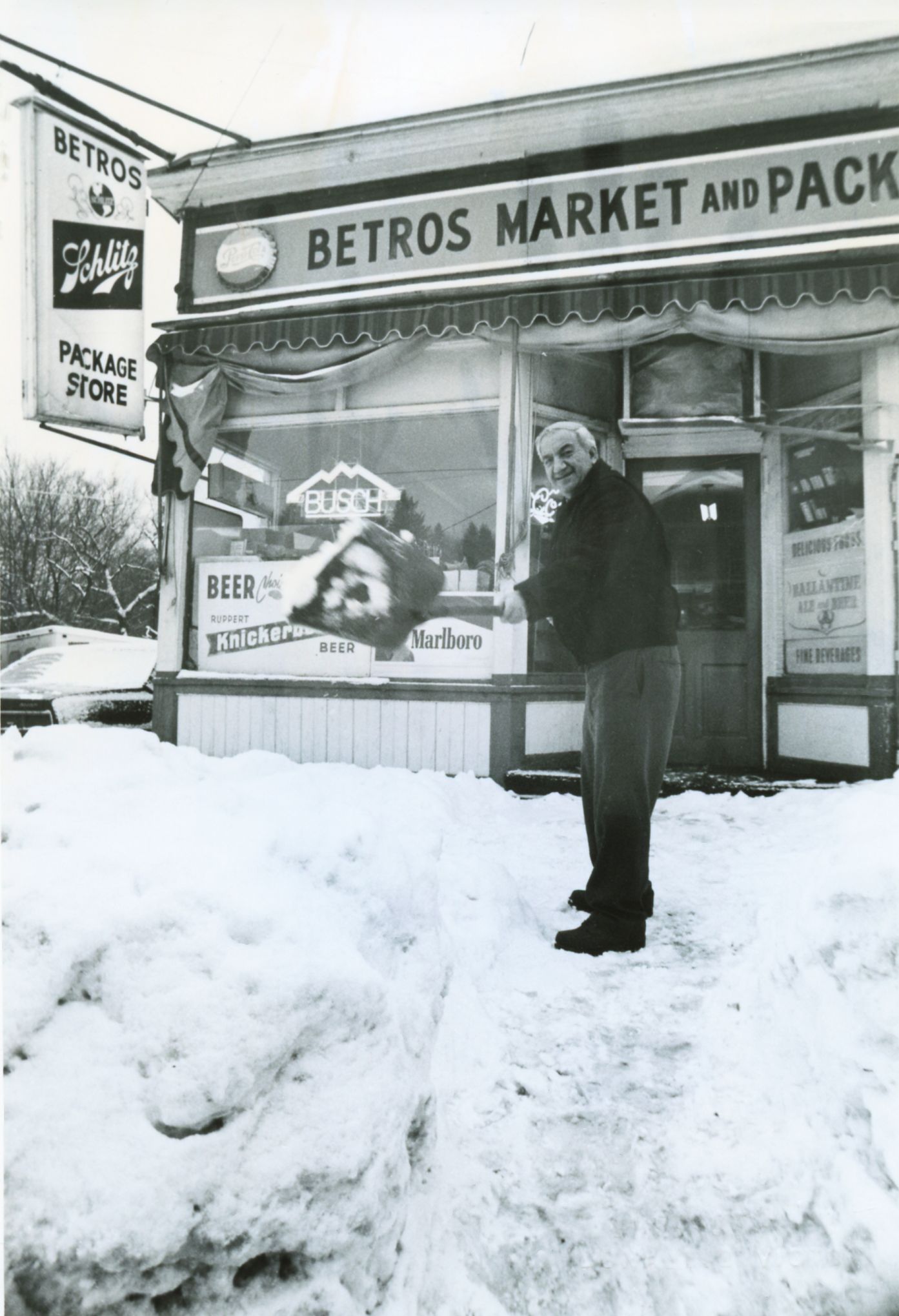 THEN: In January 1989, George Betros was busy shoveling snow in front of his market on upper Main Street in Great Barrington. Photo by Don Victor.